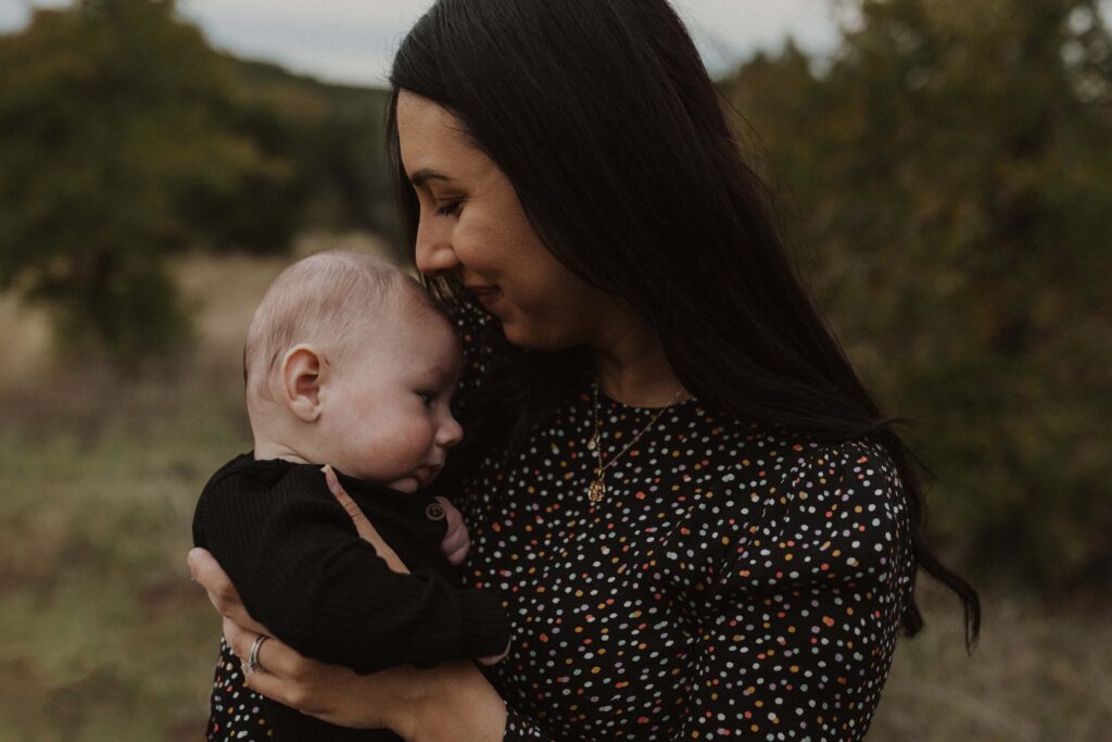 Mom carrying baby during their Texas hill country family photos.