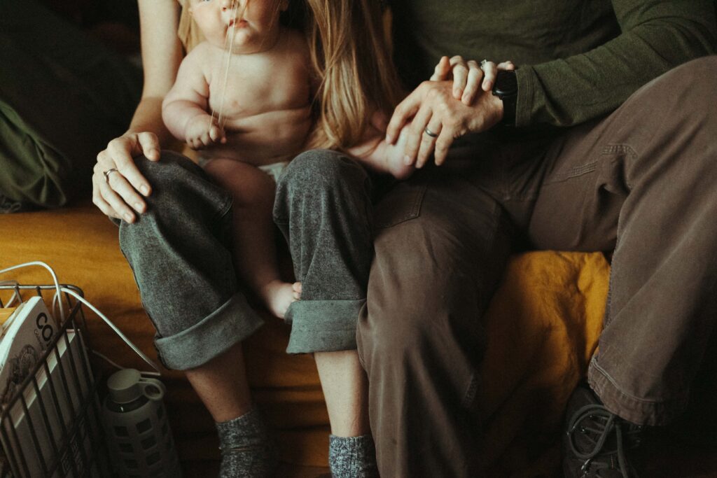 Mom, Dad and Baby's legs while baby is pulling mom's hair during their family photos in Austin Texas